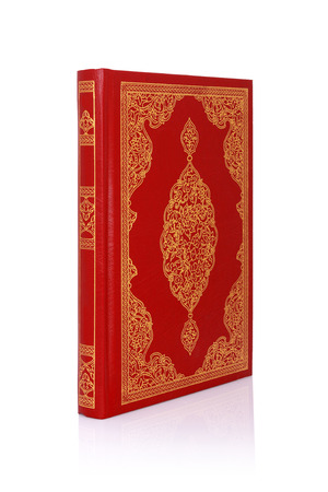 Old red book with gold color ornament on cover isolated on white の写真素材