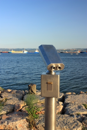 Metallic coin operated viewer for tourists to look at against coastal. Including clipping pathの写真素材