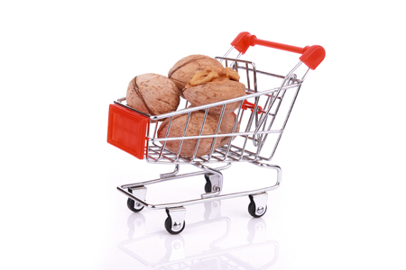 Walnuts in miniature shopping cart isolated on white backgroundの写真素材