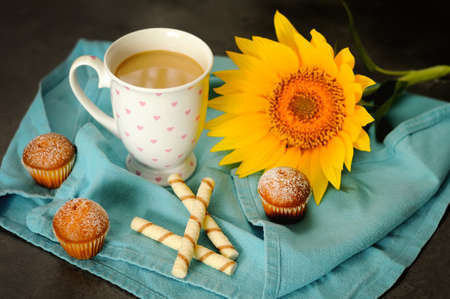A cup of coffee with milk and muffinsの写真素材