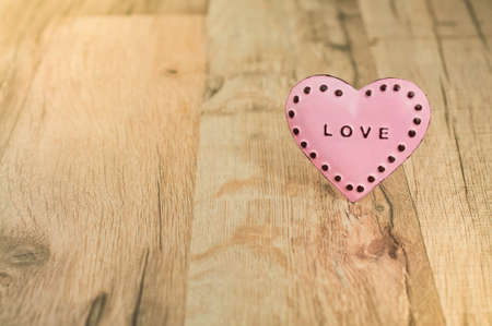 Valentines Day heart with inscription. Pink heart with place for text on the wooden background