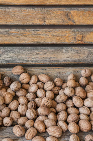 Many walnuts on a vintage wooden background. Autumn compositionの写真素材
