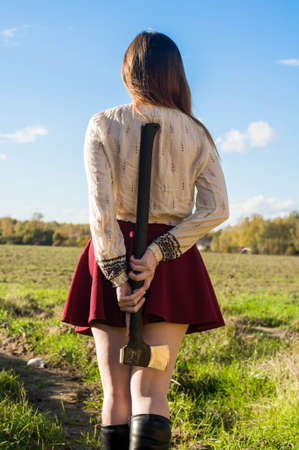 Red head girl with axe in the forest dangerの写真素材