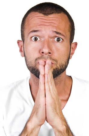 Young man in white t-shirt holding hands together, prayingの写真素材