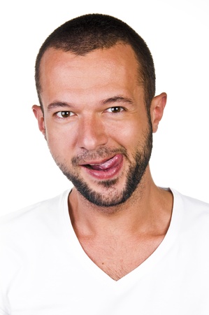 Portrait of a young man with his tongue, white backgroundの写真素材