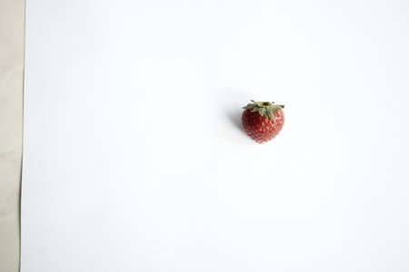 Strawberry on a white sheet of paper on a white backgroundの写真素材