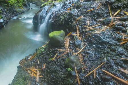 large black stone located next to a very swift river flow