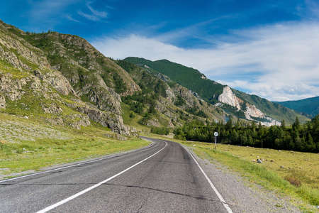 Asphalt road, leaving in the distance of mountainsの写真素材