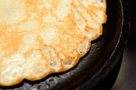 Pan fried pancake with butter, black frying pan, yellow butter pancake, background, fragmentの写真素材