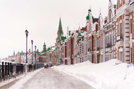 Russia, Yoshkar-Ola, Bruges embankment, March 09, 2019, cloudy winter day, view of the buildings, parapet of the embankment, brick buildings, frozen riverのeditorial素材