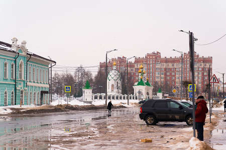Russia, Yoshkar-Ola, March 09, 2019, winter view of Voznesenskaya street, asphalt road, the building is green on the left, people are standing on the rightのeditorial素材
