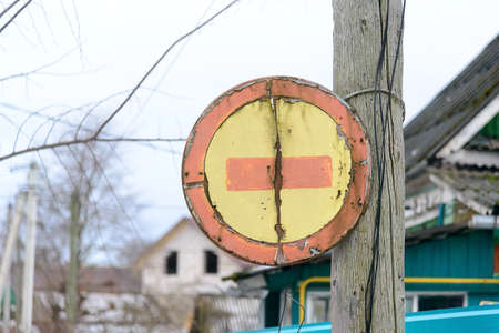 Russia, Borovsk, January 02, 2020: a road sign a brick passage is prohibited on a pillar, behind village housesのeditorial素材