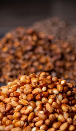 A slide of peeled yellow pine nuts. The background is blurred, Siberian pine nuts close-up.