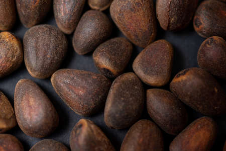 Background of pine nuts from Siberia close-up, you can see all the details of the shell. Top view of...