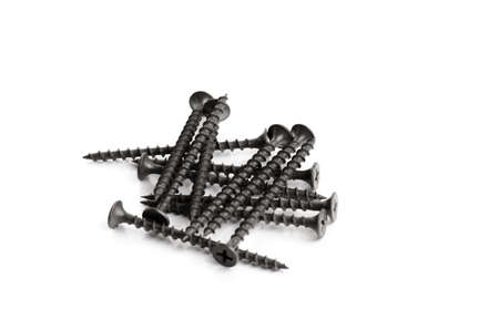 Many black metal bolts and screws isolated on whiteの写真素材