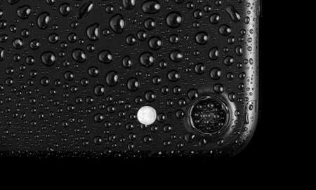 Black matte smartphone with waterdrops, isolated on whiteのeditorial素材