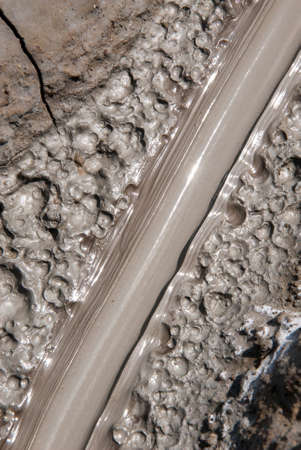 Mud Volcanoes - Texture and eruption -Romania, Buzau, Berca - Active Mud Volcanoes, Muddy Volcanoes Reservation in Mountains, View Landmark for Tourists, Landscape (unique geological phenomenon in Europe where the earth gas reaches the surface through hilの写真素材