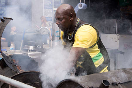 Jamaican chef cooking jerk chicken - Food Street Market Reading, UK - June2, 2018のeditorial素材