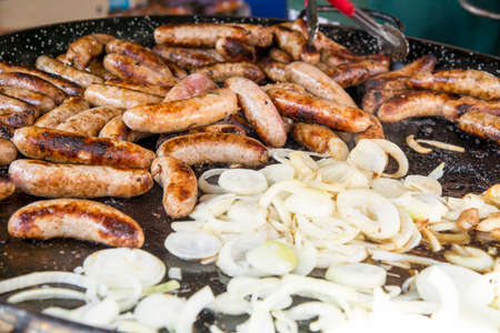 Wild Boar Sausage and Onions on grill in Food Street Market - Natural foodの写真素材