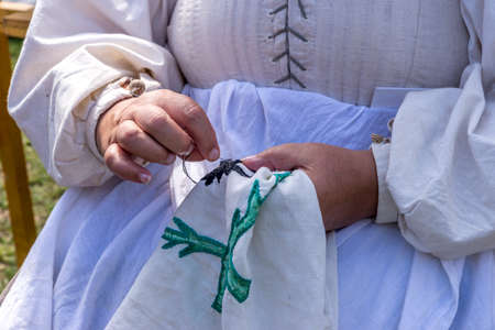 Old lady sewing outdoor - handmade traditional