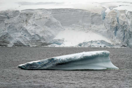 Antarctica - Non Tabular Iceberg Drifting In The Ocean - Antarctica In A Cloudy Day. Global warming