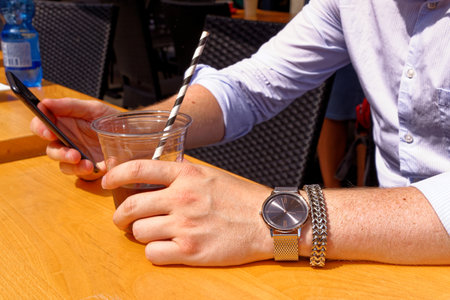 Young man having a cup of coffee wearing fashion jewelery - London, United Kingdom, 1st of June 2019