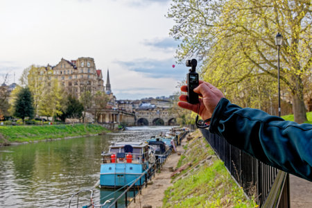 Travel destination United Kingdom - Young man filming the River Avon in the city of Bath, Somerset,...