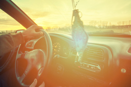 Driver's hands on steering wheel inside of a car