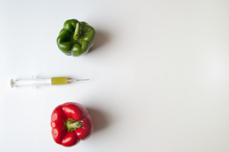 Green and reed pepper with syringe. GMOの写真素材