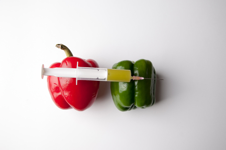 Green and reed pepper with syringe. GMOの写真素材