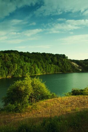 Lake with crystal clear water and green forest.の写真素材