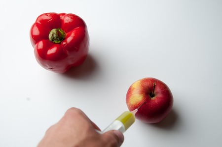 Pepper and apple infected gmo. White background.の写真素材