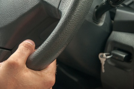 Hands on steering wheel of a car driving on an asphalt blurred roadの写真素材