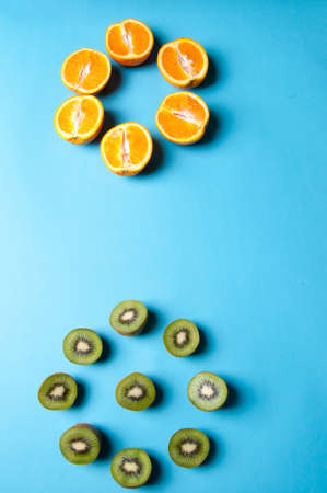 Kiwi and orange fruit on blue background.の写真素材