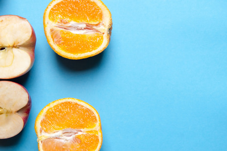 Oranges and apples on blue backgroundの写真素材
