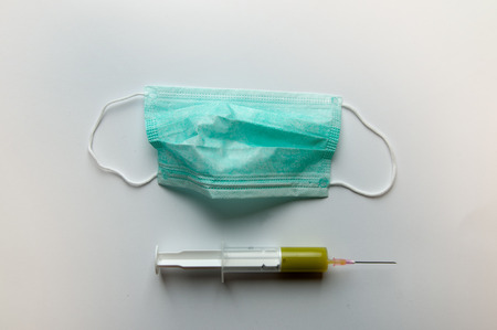 stethoscope, syringe, disposable face mask on white background