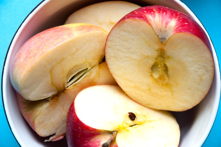 bowl of apple slices on blue backgroundの写真素材