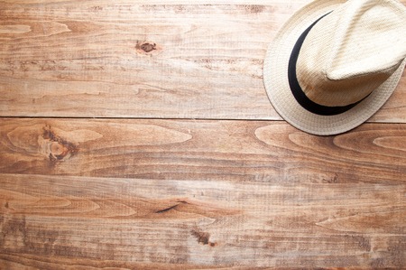 Summer hat in the middle on the wooden background.の写真素材