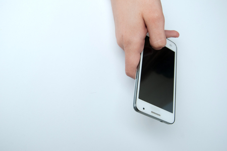 Girl holding a white smartphone. White backgroundの写真素材