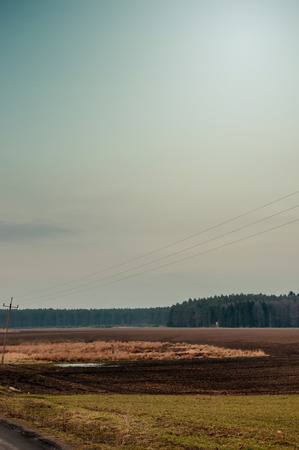 Winter or early spring landscape of field with raised hide under cloudy sky. Sad landscapeの写真素材