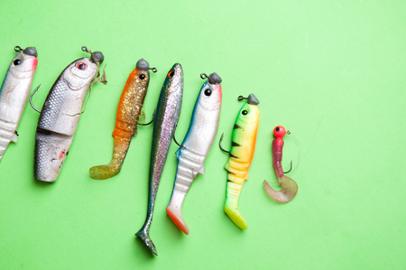 Artificial fish, fishing equipment on a green backgroundの写真素材