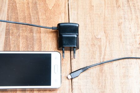 top view of white smartphone and adapter chargerの写真素材