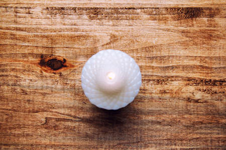 White candle isolated on a wooden tableの写真素材