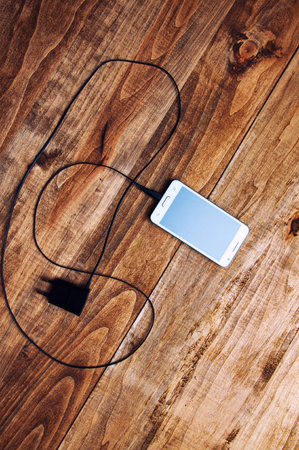 top view of white smartphone and adapter chargerの写真素材