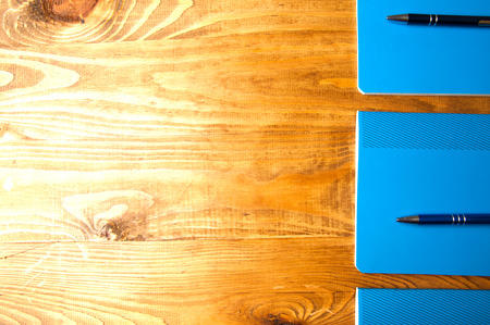 Blue school notebooks on a wooden table.