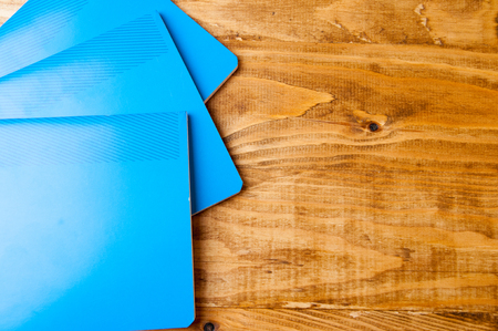 Blue school notebooks on a wooden table.