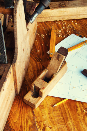 Equipment carpenter on a wooden desk with plans.の写真素材