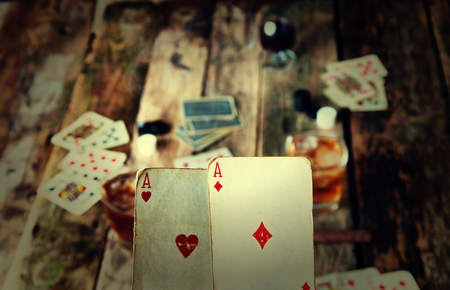 Two aces in hands on a wooden background.
