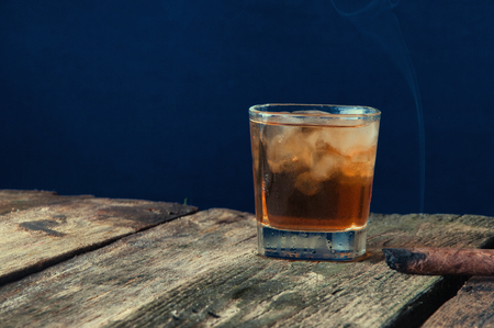 Cigar and whiskey on the old wooden background.の写真素材