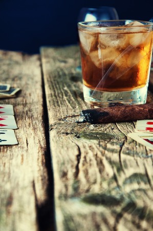 Whiskey, cigar and cards on a wooden background.の写真素材